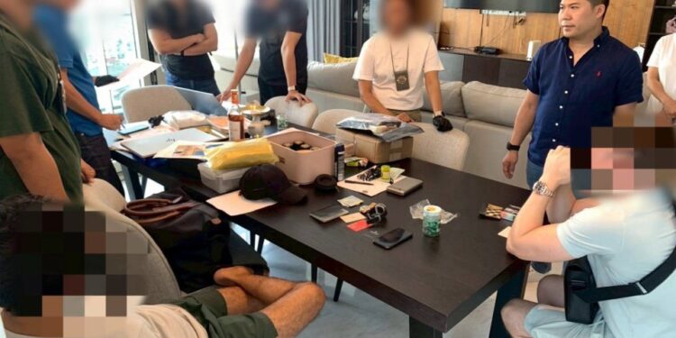 Personal policial y sospechosos se reúnen alrededor de una mesa con presuntos paquetes de droga.
