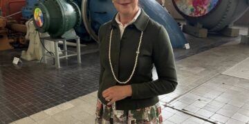 Iris Stalzer parada frente a un gran equipo industrial.