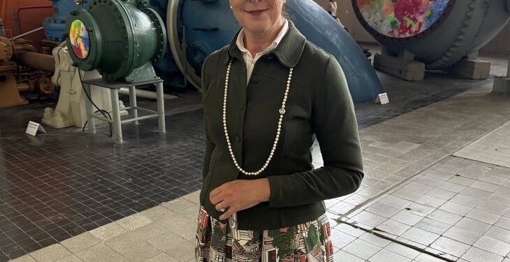 Iris Stalzer parada frente a un gran equipo industrial.