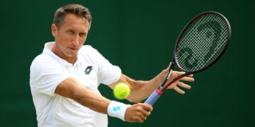 El ex tenista Sergiy Stakhovsky golpea un golpe de derecha con una pelota de tenis en movimiento.