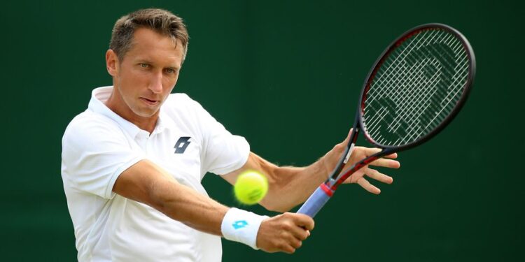 El ex tenista Sergiy Stakhovsky golpea un golpe de derecha con una pelota de tenis en movimiento.