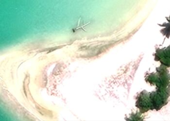 Una vista aérea de una isla con restos de aviones en el agua.