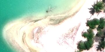 Una vista aérea de una isla con restos de aviones en el agua.