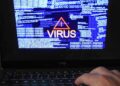Foto de archivo sin fecha que muestra un "virus" Códigos binarios y de advertencia en la pantalla de una computadora. (Peter Byrne/PA)
