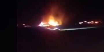 Imagen nocturna de un gran incendio en el suelo, iluminando el oscuro entorno.