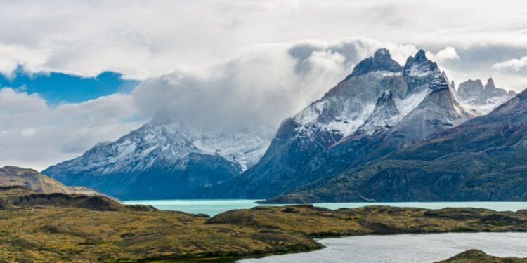 Un collage de imágenes que contiene 1 imágenes. La imagen 1 muestra montañas cubiertas de nieve parcialmente cubiertas por nubes y niebla, con agua turquesa en primer plano en el Parque Nacional Torres del Paine, Patagonia, Chile.