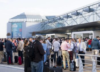Un collage de imágenes que contiene 1 imagen. La imagen 1 muestra la cola de pasajeros fuera del aeropuerto de Bruselas debido a un corte de energía.