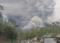 Enorme nube de ceniza procedente de la erupción del volcán Monte Semeru con gente huyendo debajo.