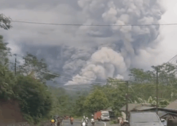 Enorme nube de ceniza procedente de la erupción del volcán Monte Semeru con gente huyendo debajo.