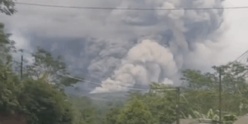Enorme nube de ceniza procedente de la erupción del volcán Monte Semeru con gente huyendo debajo.