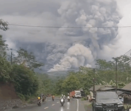 Enorme nube de ceniza procedente de la erupción del volcán Monte Semeru con gente huyendo debajo.