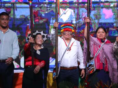 El nuevo presidente de la CONAIE, Marlon Vargas, sostiene una lanza simbólica en el escenario durante su toma de posesión en la ciudad amazónica de Puyo, Pastaza, Ecuador, el 9 de agosto de 2025.