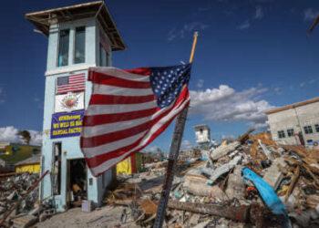 Una bandera estadounidense ondea frente a lo que queda de un centro comercial tras el paso del huracán Ian en Fort Myers Beach, Florida, el 7 de noviembre de 2022.