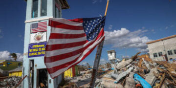 Una bandera estadounidense ondea frente a lo que queda de un centro comercial tras el paso del huracán Ian en Fort Myers Beach, Florida, el 7 de noviembre de 2022.