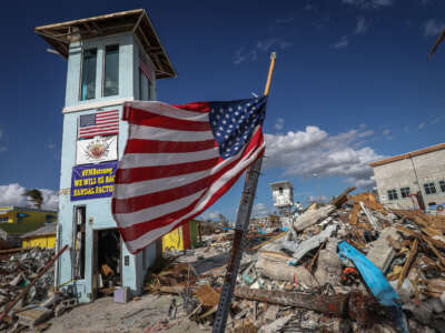 Una bandera estadounidense ondea frente a lo que queda de un centro comercial tras el paso del huracán Ian en Fort Myers Beach, Florida, el 7 de noviembre de 2022.