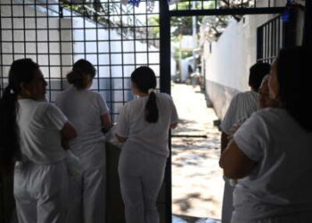 Mujeres encarceladas miran desde una puerta durante la celebración del 204 aniversario de la independencia de El Salvador en la prisión de Apanteos en Santa Ana, El Salvador, el 30 de septiembre de 2025.