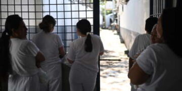 Mujeres encarceladas miran desde una puerta durante la celebración del 204 aniversario de la independencia de El Salvador en la prisión de Apanteos en Santa Ana, El Salvador, el 30 de septiembre de 2025.