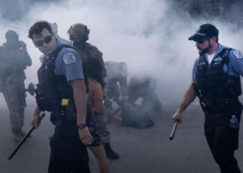 Oficiales de policía de Chicago y agentes federales encargados de hacer cumplir la ley se encuentran en una nube de gas lacrimógeno desplegado por agentes federales contra manifestantes en Broadview, Illinois, el 4 de octubre de 2025. La protesta estalló después de que un agente de Aduanas y Protección Fronteriza disparó a un manifestante anti-ICE en Brighton Park.