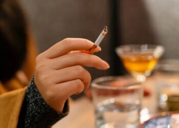 Un collage de imágenes que contiene 1 imágenes. La imagen 1 muestra a una mujer fumando un cigarrillo en una taberna.