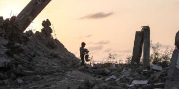 Un joven palestino recoge un trozo de escombros en Nuseirat, Franja de Gaza, el 11 de noviembre de 2025.