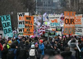 Los manifestantes se manifiestan durante la Marcha Popular en Washington en Washington, DC el 18 de enero de 2025, antes de la toma de posesión del presidente electo de Estados Unidos, Donald Trump.