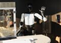 Un robot Tesla Optimus recoge palomitas de maíz y saluda a los asistentes en el restaurante Tesla Diner and Drive-In y Supercharger en Los Ángeles, California, el 21 de julio de 2025. (Patrick T. Fallon/AFP/Getty Images)