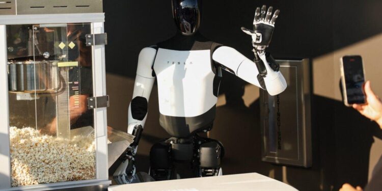 Un robot Tesla Optimus recoge palomitas de maíz y saluda a los asistentes en el restaurante Tesla Diner and Drive-In y Supercharger en Los Ángeles, California, el 21 de julio de 2025. (Patrick T. Fallon/AFP/Getty Images)