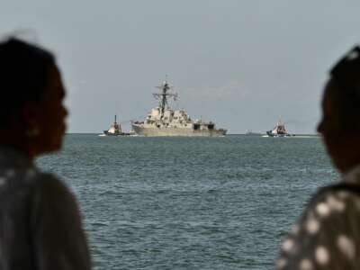 La gente observa al USS Gravely, un buque de guerra de la Armada de los EE. UU., que sale de Puerto España el 30 de octubre de 2025. El buque de guerra llegó a Trinidad y Tobago el 26 de octubre de 2025 para realizar ejercicios conjuntos cerca de la costa de Venezuela.