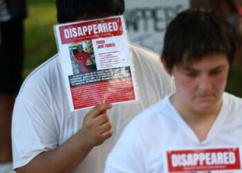 Personas recrean detenciones en el Centro de Confinamiento del Terrorismo (CECOT) durante la "Los buenos problemas siguen vivos" manifestación y marcha de protesta en Washington, DC