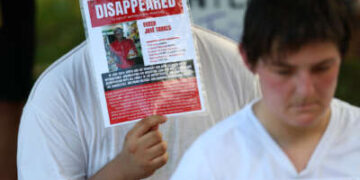 Personas recrean detenciones en el Centro de Confinamiento del Terrorismo (CECOT) durante la "Los buenos problemas siguen vivos" manifestación y marcha de protesta en Washington, DC