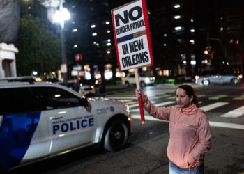 Una mujer sostiene un cartel durante una protesta contra la Patrulla Fronteriza de EE. UU. y el Servicio de Inmigración y Control de Aduanas (ICE) frente al Edificio Federal Hale Boggs en Nueva Orleans, Luisiana, el 6 de diciembre de 2025.