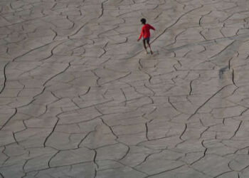 Jóvenes caminan por el lecho seco de un río a orillas del río Ganges en Prayagraj, India, el 14 de octubre de 2025.
