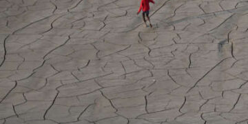 Jóvenes caminan por el lecho seco de un río a orillas del río Ganges en Prayagraj, India, el 14 de octubre de 2025.