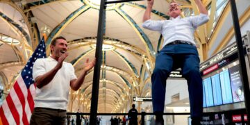 El influyente Dr. Paul Saladino observa al Secretario de Transporte, Sean P. Duffy, hacer flexiones después de una conferencia de prensa sobre el lanzamiento del "Haga que los viajes vuelvan a ser familiares" Campaña en el Aeropuerto Nacional Ronald Reagan de Washington en Arlington, Virginia, el 8 de diciembre de 2025. (Heather Diehl/Getty Images)