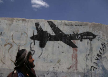 Un hombre yemení mira los graffitis que protestan contra los ataques con aviones no tripulados estadounidenses el 19 de septiembre de 2018 en Saná, Yemen.