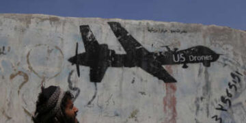 Un hombre yemení mira los graffitis que protestan contra los ataques con aviones no tripulados estadounidenses el 19 de septiembre de 2018 en Saná, Yemen.