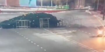 Extraño momento: un conductor aplasta y derriba un árbol de Navidad de 40 pies en la plaza principal de la ciudad en un loco paseo en un motor averiado