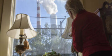Marti Blake mira por la ventana delantera la chimenea de la central eléctrica de carbón de Cheswick en Springdale, Pensilvania, el 27 de octubre de 2017. Blake dice que la cantidad de dióxido de azufre, óxido de nitrógeno y partículas de carbón que se originan en la planta ha afectado su salud y la de quienes se encuentran en el área circundante.