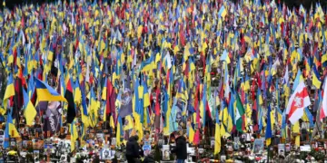 La gente llora ante las tumbas de militares ucranianos en el cementerio de Lychakiv el Día de las Fuerzas Armadas de Ucrania, en Lviv, el 6 de diciembre de 2025. (Yuriy Dyachyshyn/AFP vía Getty Images)