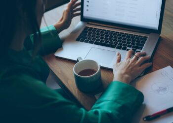 Un collage de imágenes que contiene 1 imagen. La imagen 1 muestra a una mujer de negocios irreconocible trabajando en su computadora portátil en la oficina.