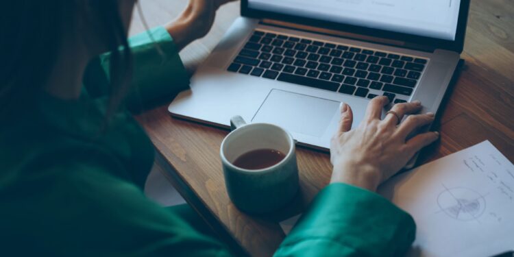 Un collage de imágenes que contiene 1 imagen. La imagen 1 muestra a una mujer de negocios irreconocible trabajando en su computadora portátil en la oficina.