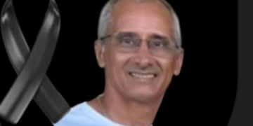 Un hombre sonriente con una cinta negra.