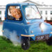 Ilustración de Donald Trump conduciendo un diminuto azul "TRIUNFO T50" coche lejos de la Casa Blanca.