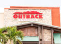 Restaurante Outback Steakhouse con letrero rojo, arquitectura de logotipo, entrada, fachada, escaparate de negocios en los Cayos de Florida, palmeras