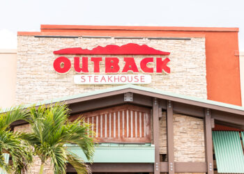 Restaurante Outback Steakhouse con letrero rojo, arquitectura de logotipo, entrada, fachada, escaparate de negocios en los Cayos de Florida, palmeras