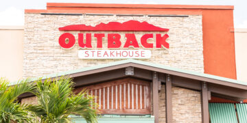 Restaurante Outback Steakhouse con letrero rojo, arquitectura de logotipo, entrada, fachada, escaparate de negocios en los Cayos de Florida, palmeras