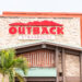 Restaurante Outback Steakhouse con letrero rojo, arquitectura de logotipo, entrada, fachada, escaparate de negocios en los Cayos de Florida, palmeras
