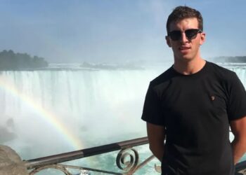 Un collage de imágenes que contiene 1 imagen. La imagen 1 muestra a un hombre con gafas de sol y camisa negra parado frente a las Cataratas del Niágara con un arco iris y un barco debajo.