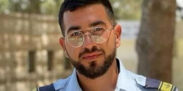 Un collage de imágenes que contiene 1 imagen. La imagen 1 muestra a Ran Gvili, un rehén, vestido con una camisa de uniforme azul claro con charreteras, barba y gafas.