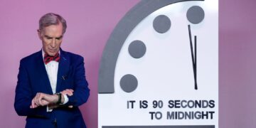 Un collage de imágenes que contiene 1 imagen. La imagen 1 muestra al educador científico Bill Nye mirando su reloj junto al "Reloj del fin del mundo" establecido en 90 segundos para la medianoche